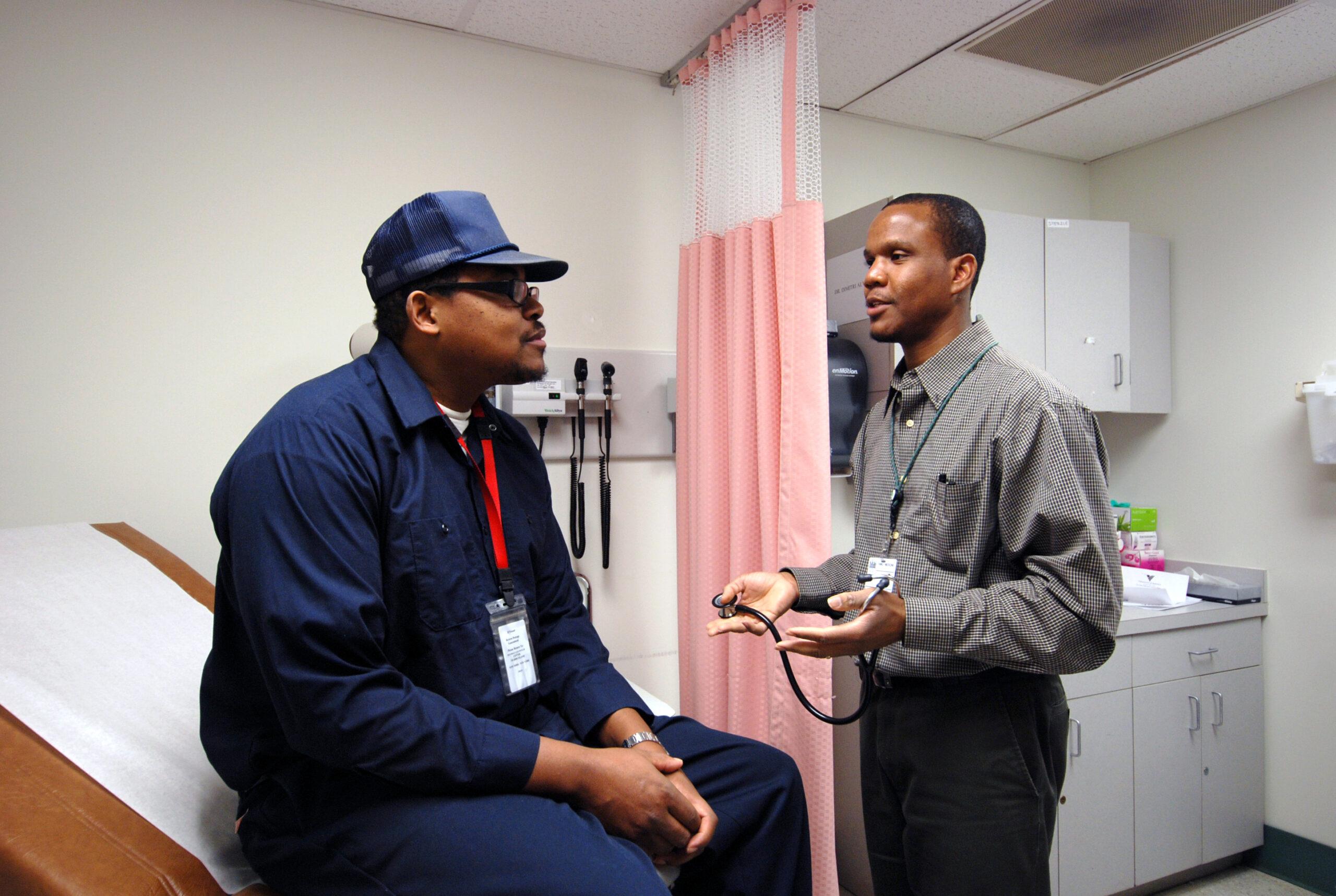 A doctor meets with a patient in an exam room.